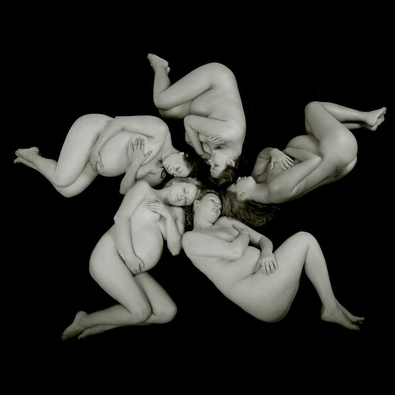 five naked pregnant women lying in a circle